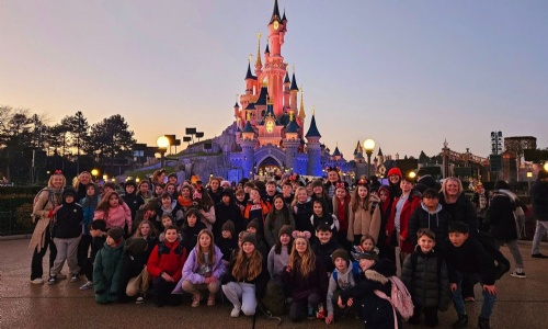 Exwick Heights Primary School stood in Disney Land Paris, with a magical castle in the background. 