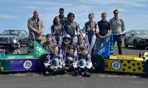 GreenPower engineering and racing team stood next to race cars