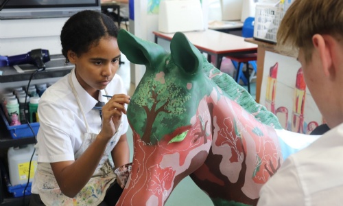 Student painting model donkey