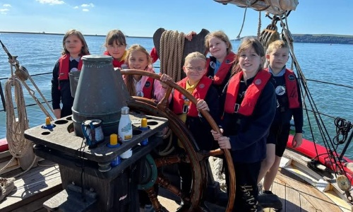 Marine Academy Pupils on a sailing boat, at the helm
