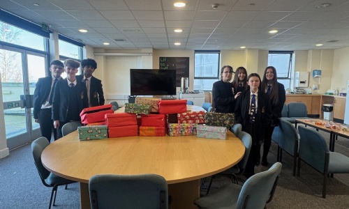 Students from St Luke's stood around a table with thier filled shoeboxes