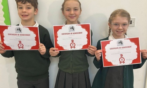 Children from Exwick Heights holding certificates