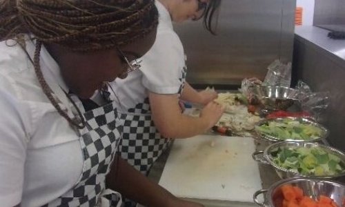 All Saints Students chopping veg in the kitchen
