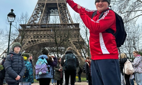 students holding up the eiffel tower