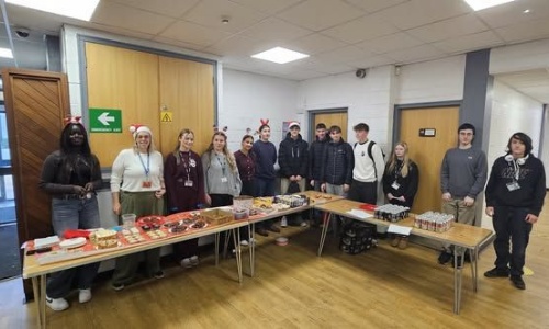 Lipson Students stading behin tables at their bake sale