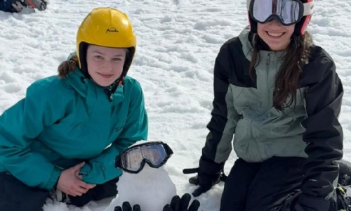 Isca Students making a mini snow man and sat on the snow in Spin