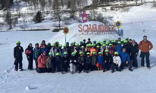 Group of students in ski gear smiling for a group photo.