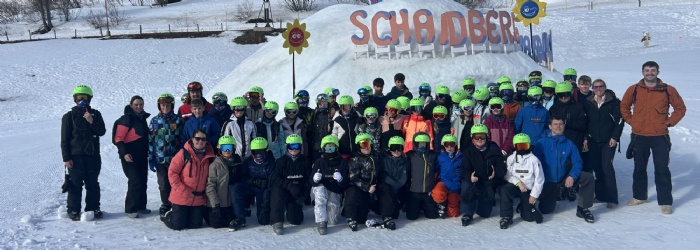 Group of students in ski gear smiling for a group photo.